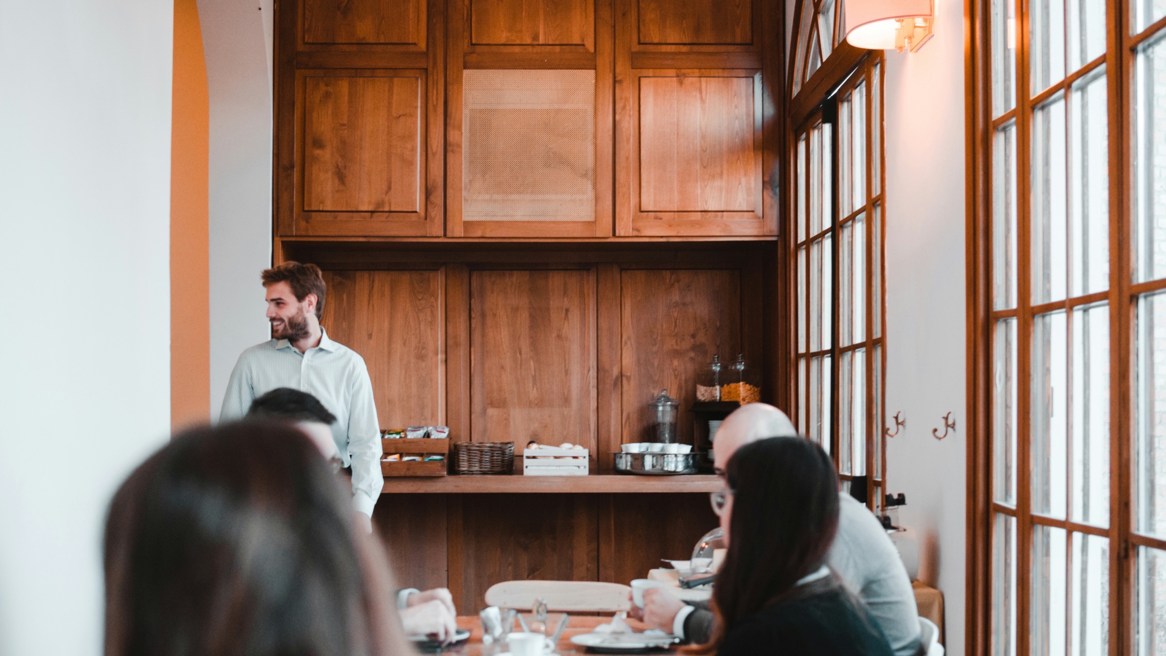 Een teamlid spreekt collega's toe tijdens een briefing in een hospitalityzaak